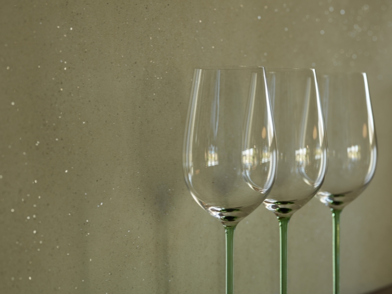 Lehm-Designputz mit Strukturelementen auf graugrüner Wand von Claytec 